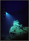 Diver Lights Up Tank On Deep Wreck